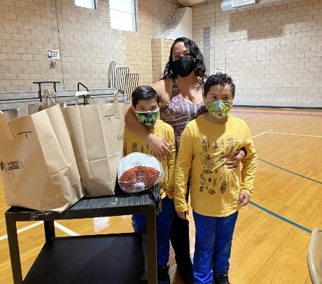 A TCCI family receives fresh goods and produce at  one of FSC’s holiday giveaway events.